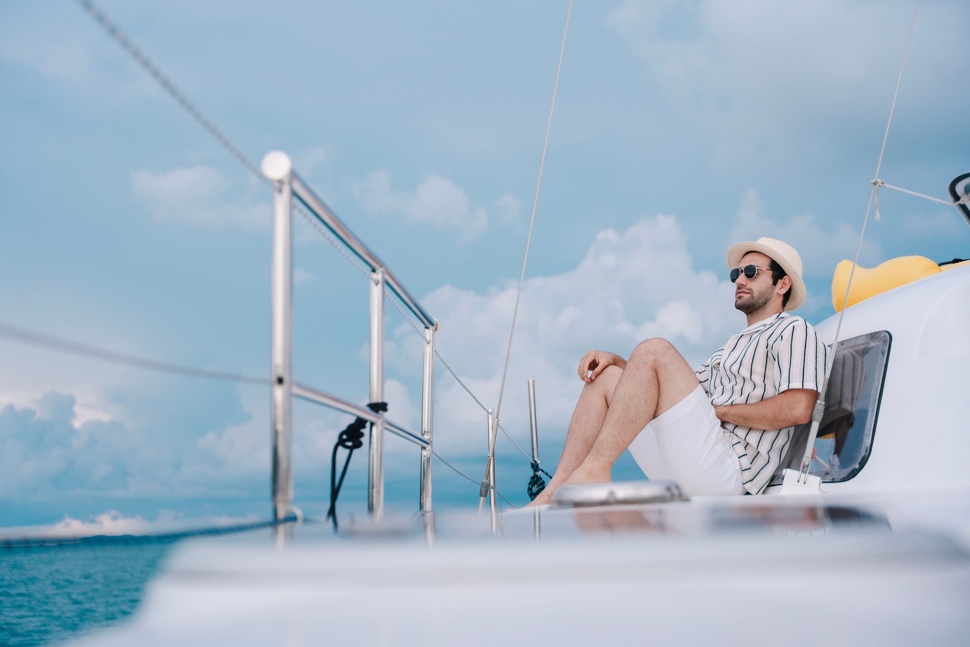 Man outdoors posing on yacht in sea.
